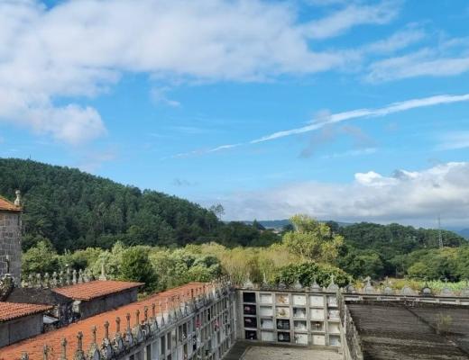 Scenery of a gothic cathedral and green rolling hills on the Camino de Santiago trek