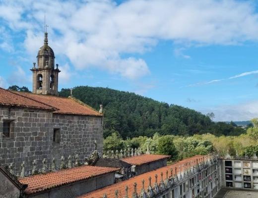 Scenery of a gothic cathedral and green rolling hills on the Camino de Santiago trek