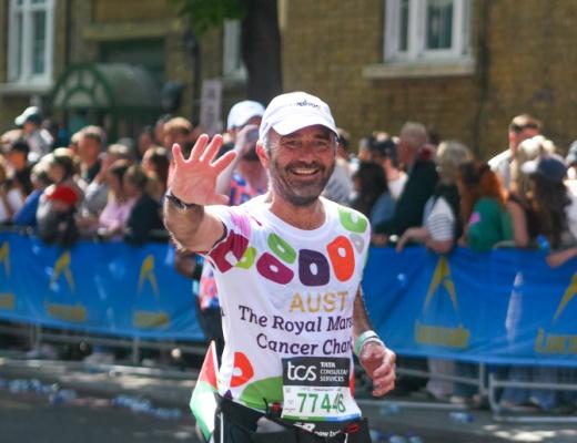 Team Marsden runner, Adam, waves at the camera and smiles during London Marathon 2025
