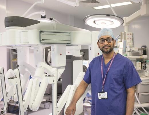 Professor Vinidh Paleri in blue scrubs and a Royal Marsden lanyard around his neck